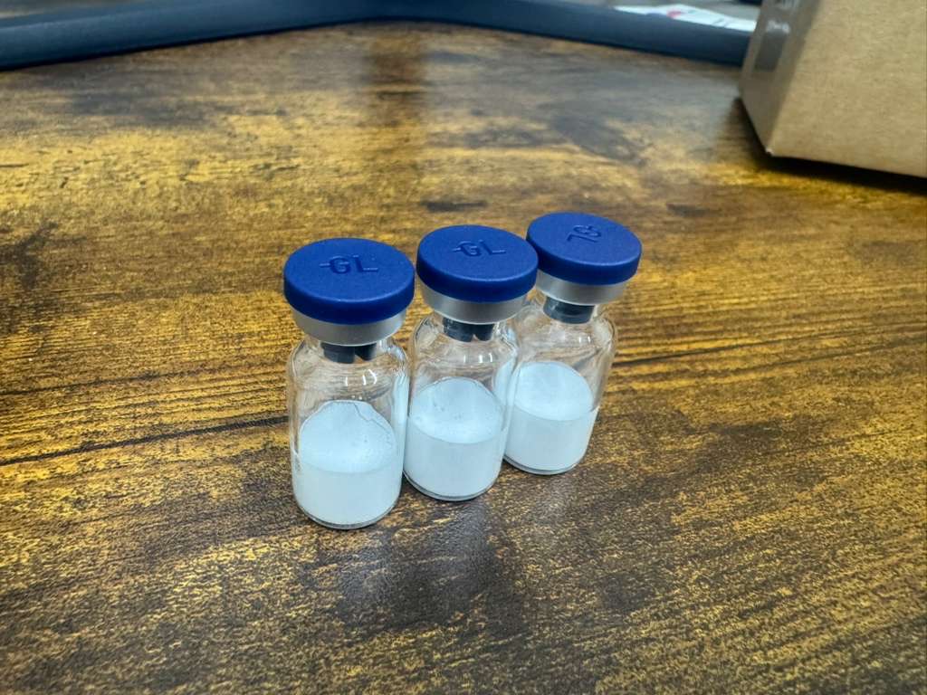 Three peptide vials with white lyophilized cakes after small-batch freeze drying